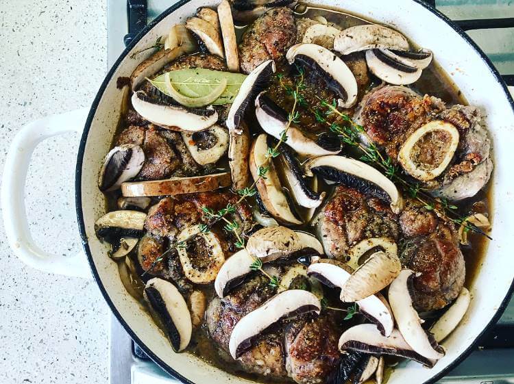 Ossobuco cooking with mushrooms and herbs