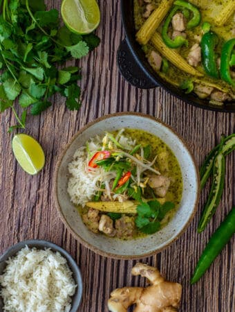 thai green curry in a bowl, coriander, ginger & rice on table