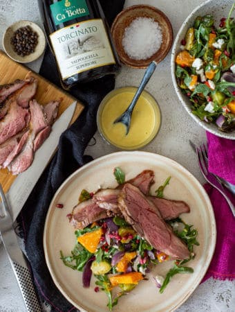 grilled lamb & veg salad, bottle of red wine and cooked sliced lamb