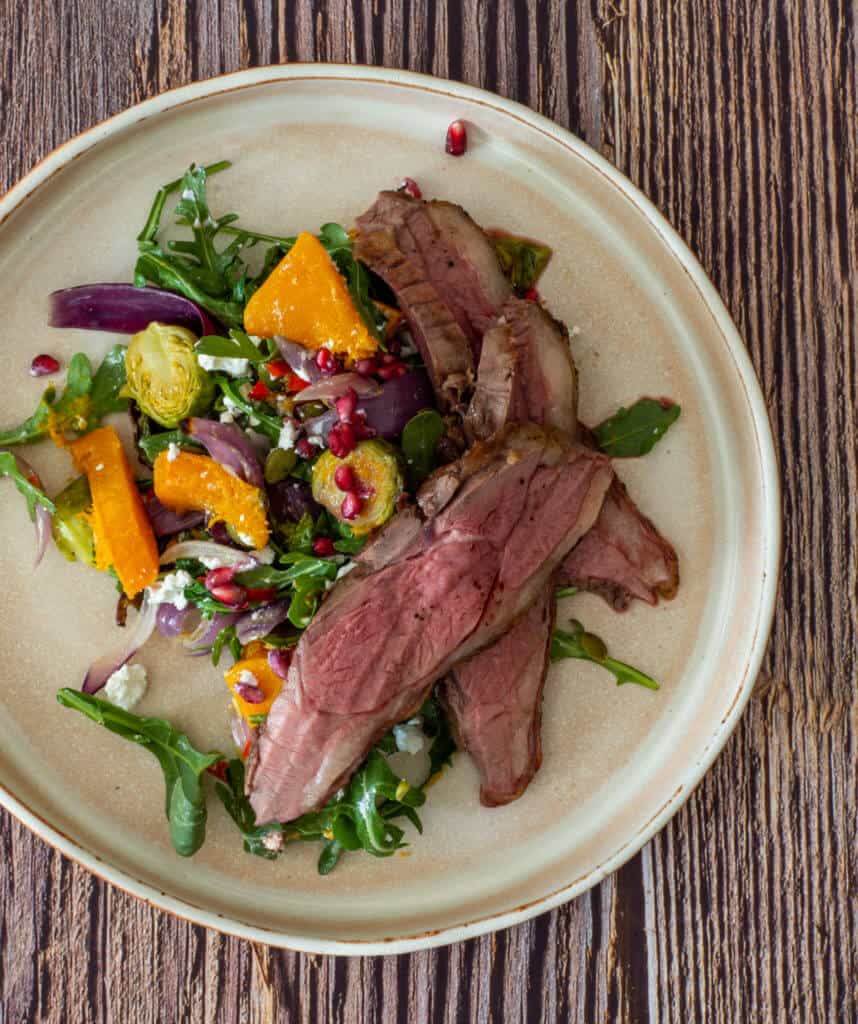 cooked lamb, veg salad on a plate