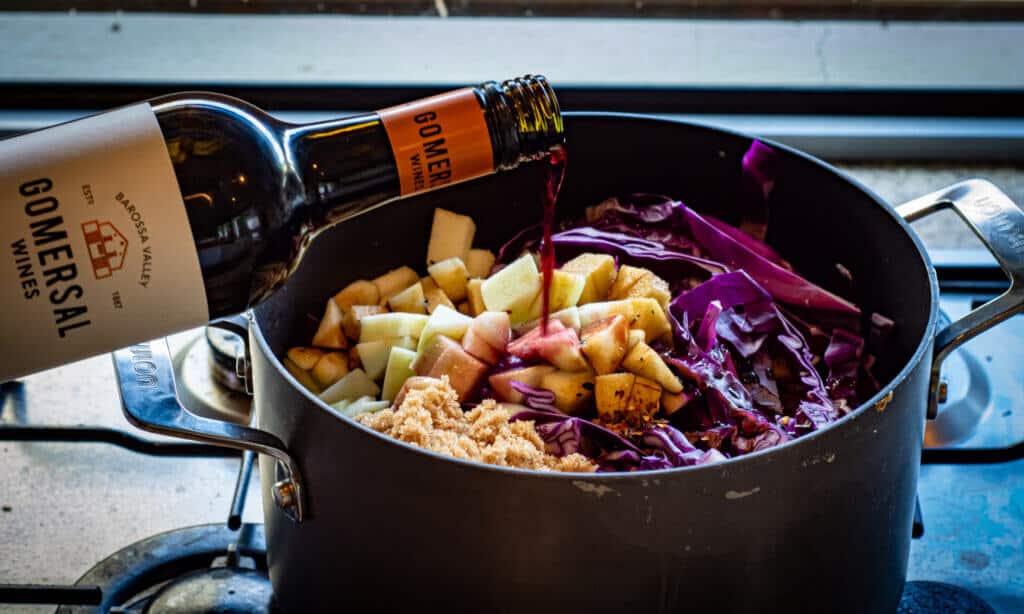 red cabbage ingredients in pot and bottle of red wine