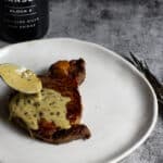peppercorn sauce being spooned over steak & manser red wine