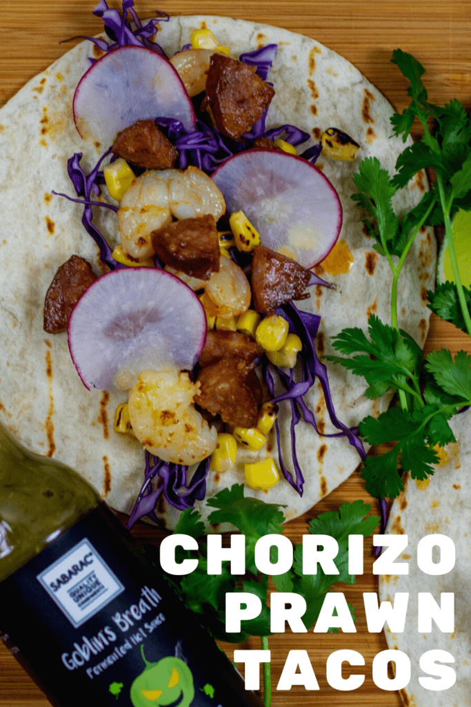chorizo & prawn tacos on chopping board with sabarac hot sauce