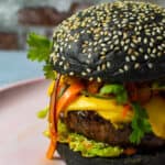 angled view of korean beef burger on a pink plate