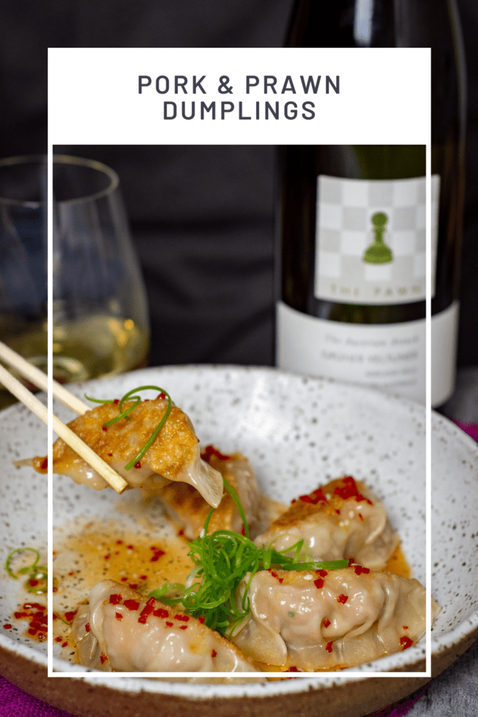 someone eating pork & prawm dumplings with chopsticks and a bottle of The Pawn Wine Co gruner veltliner in background