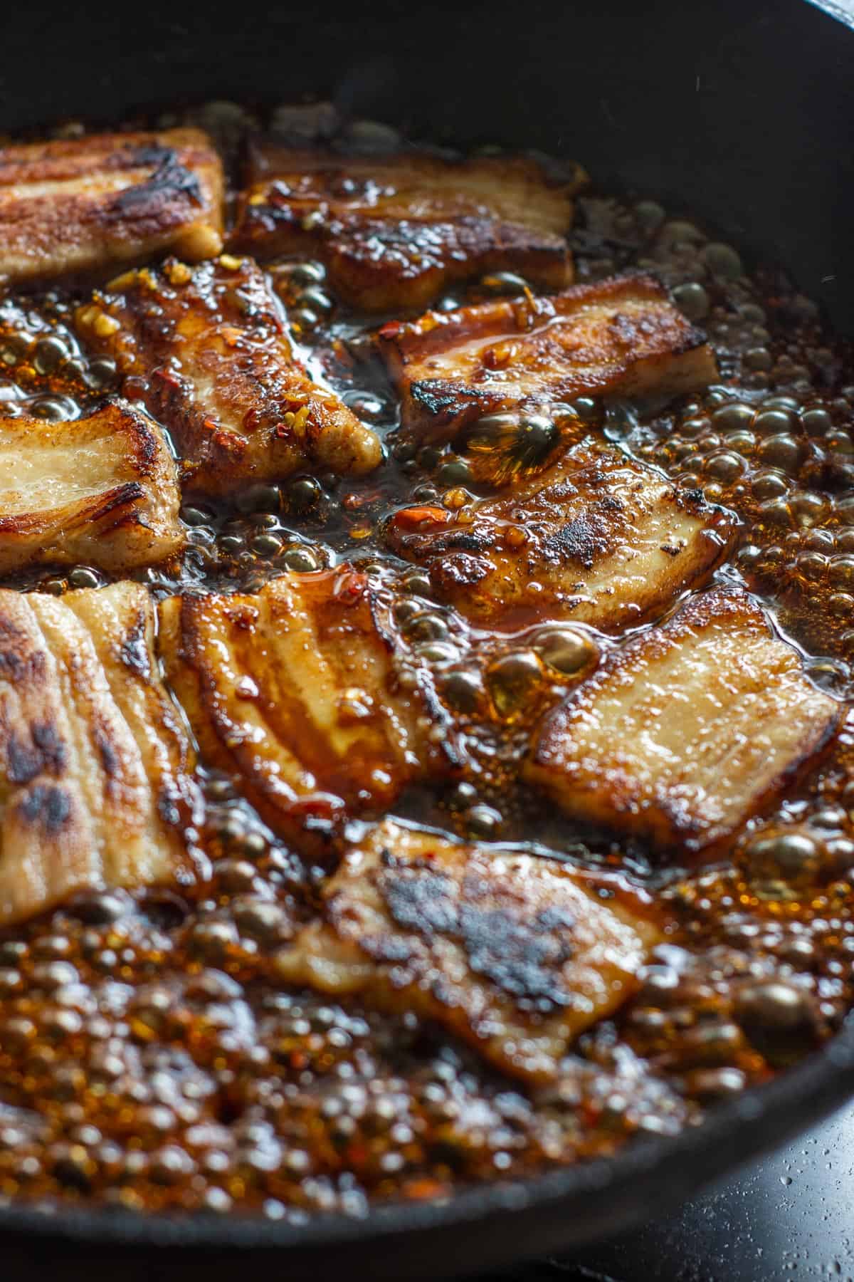 pork belly being cooked in a glaze