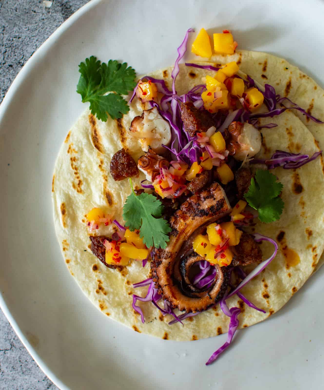 octopus tacos on a white plate