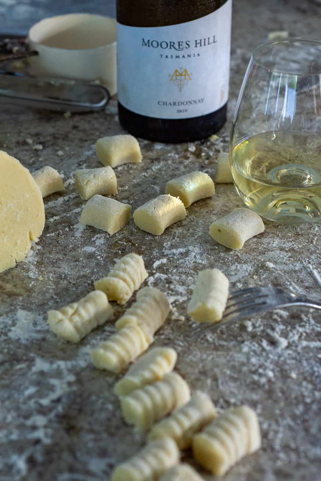 gnocchi being rolled over a fork and moores hill chardonnay