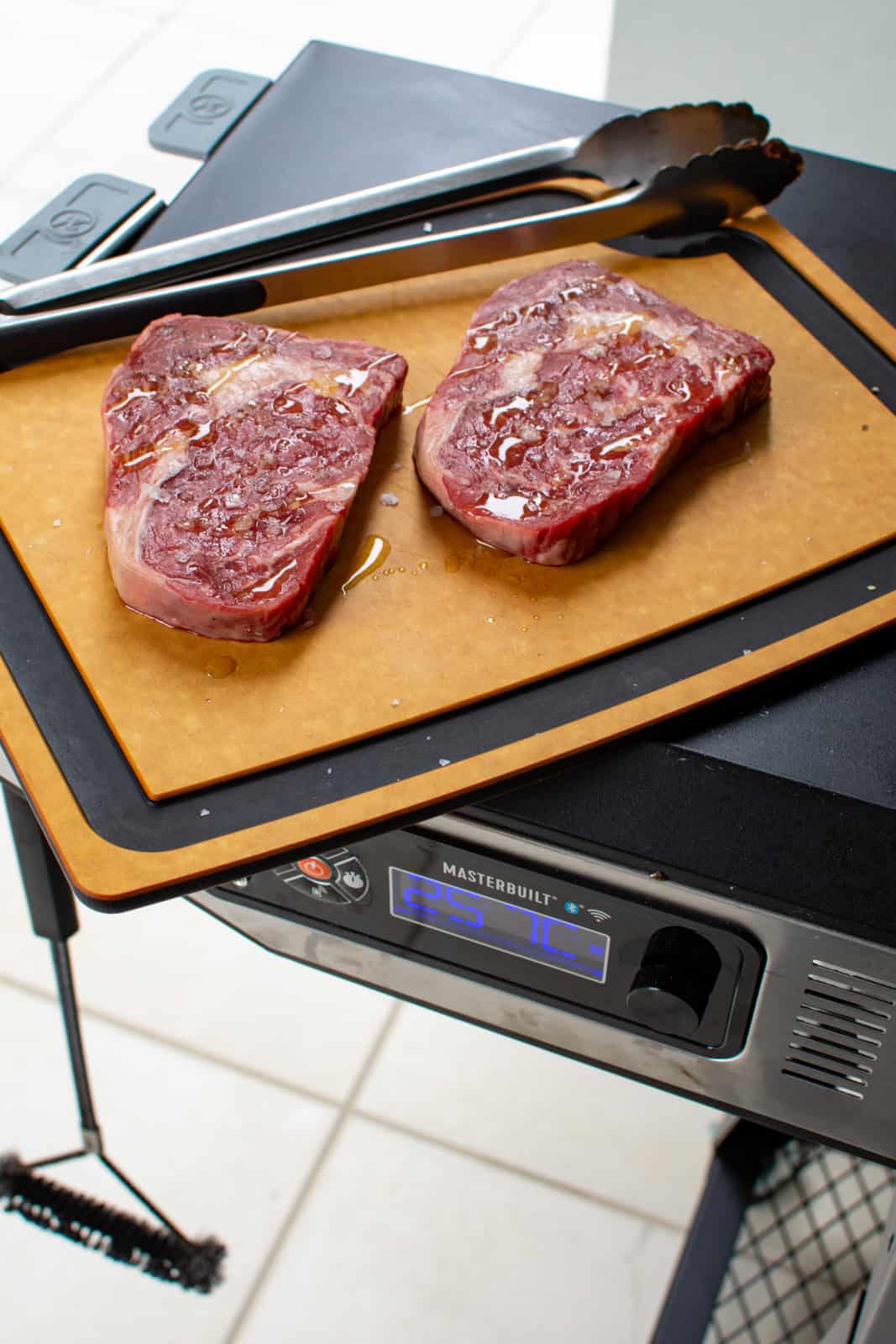 scotch steaks on a chopping board next to BBQ