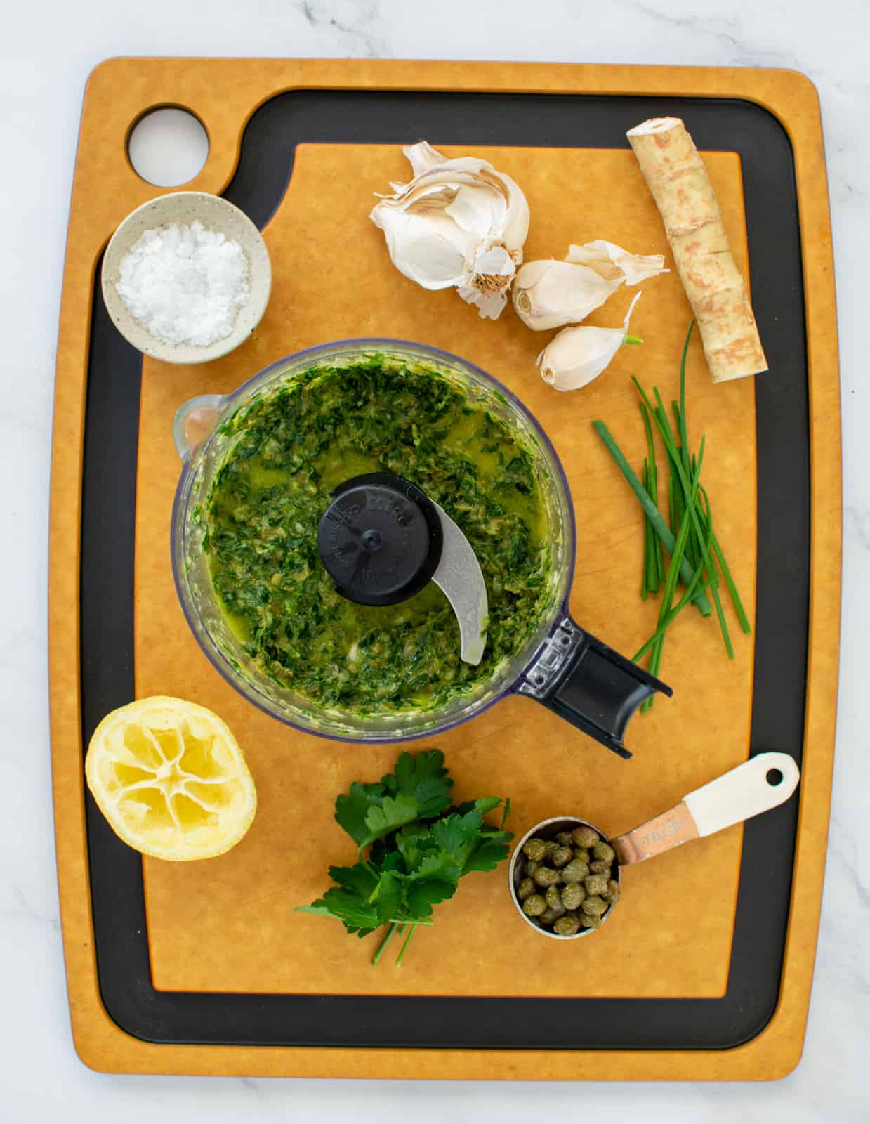 horseradish salsa verde in food processor and ingredients on chopping board 