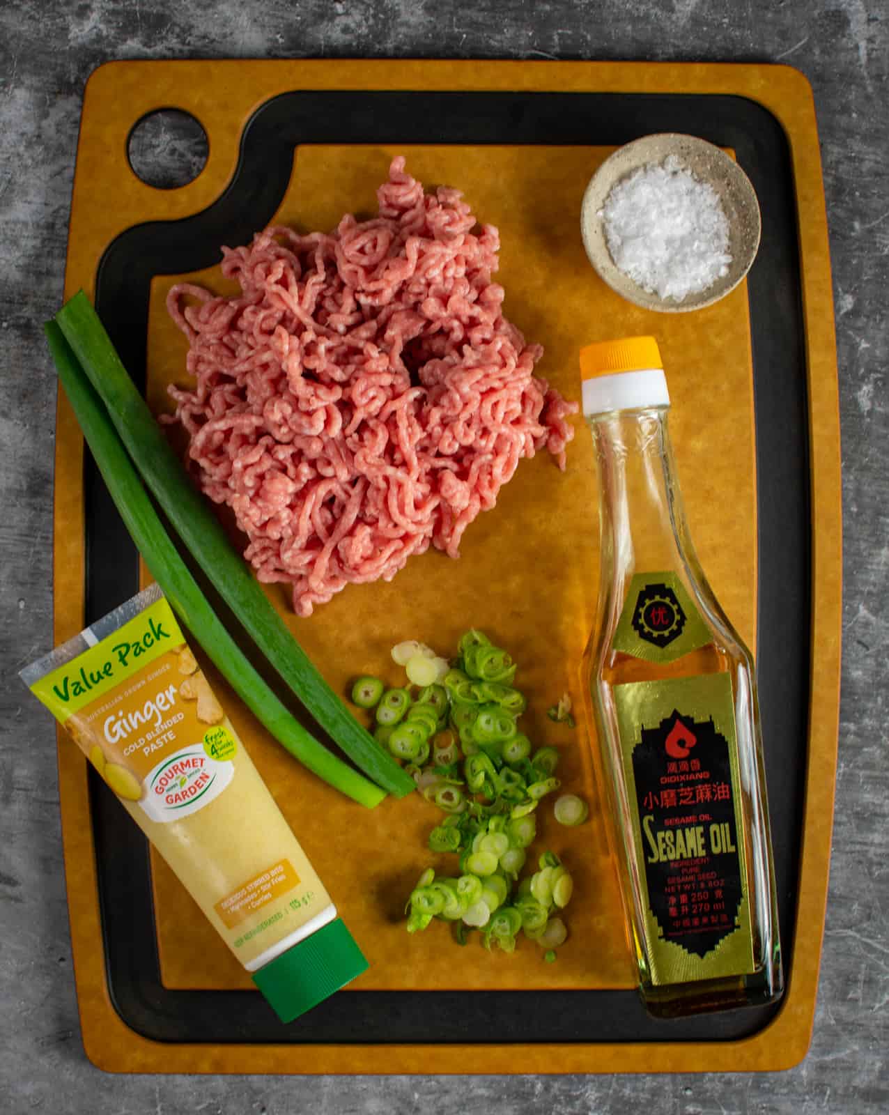 pork meatball ingredients on a chopping board 