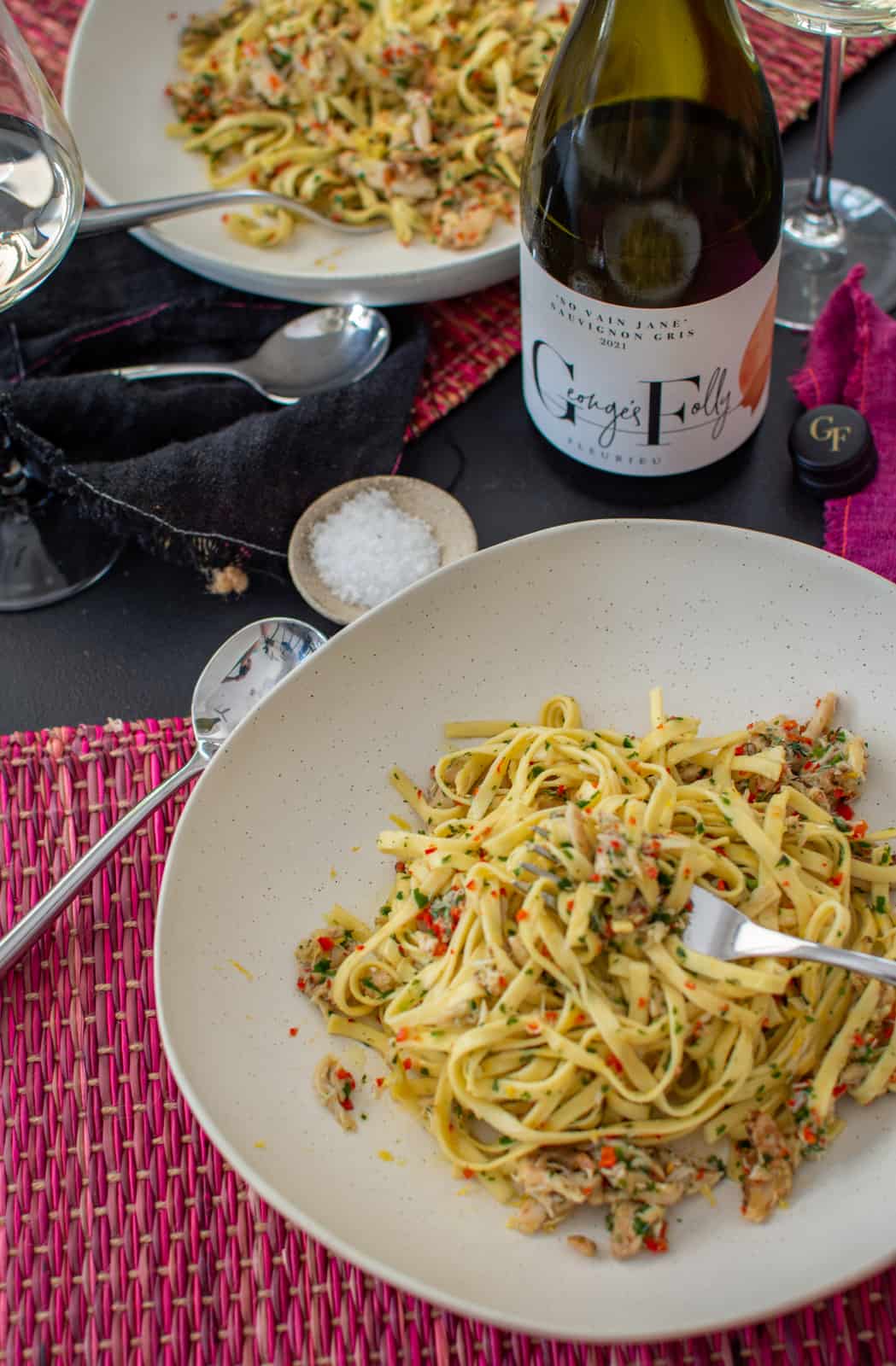 bowls of crab pasta on a table with Georges Folly wine