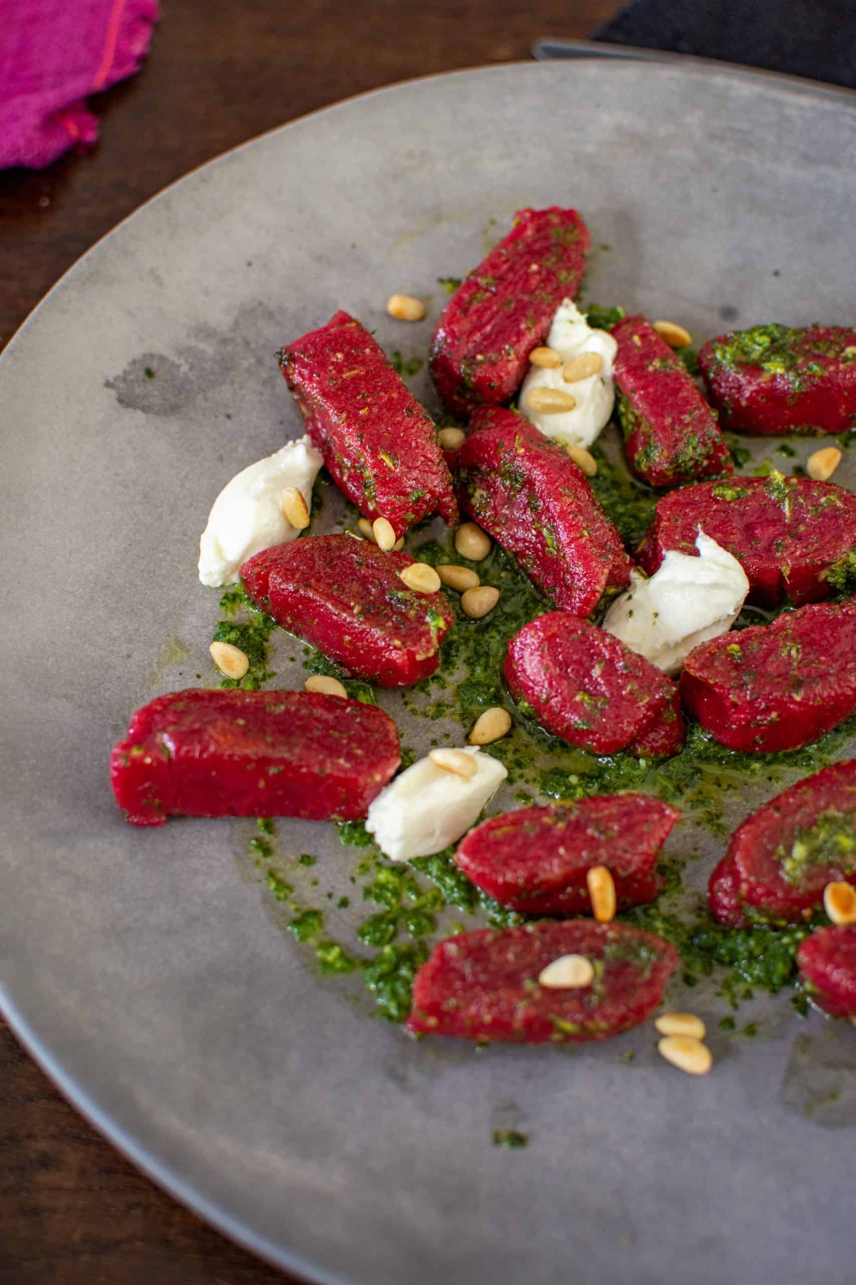 A plate of beetroot gnocchi with goat cheese & kale pesto