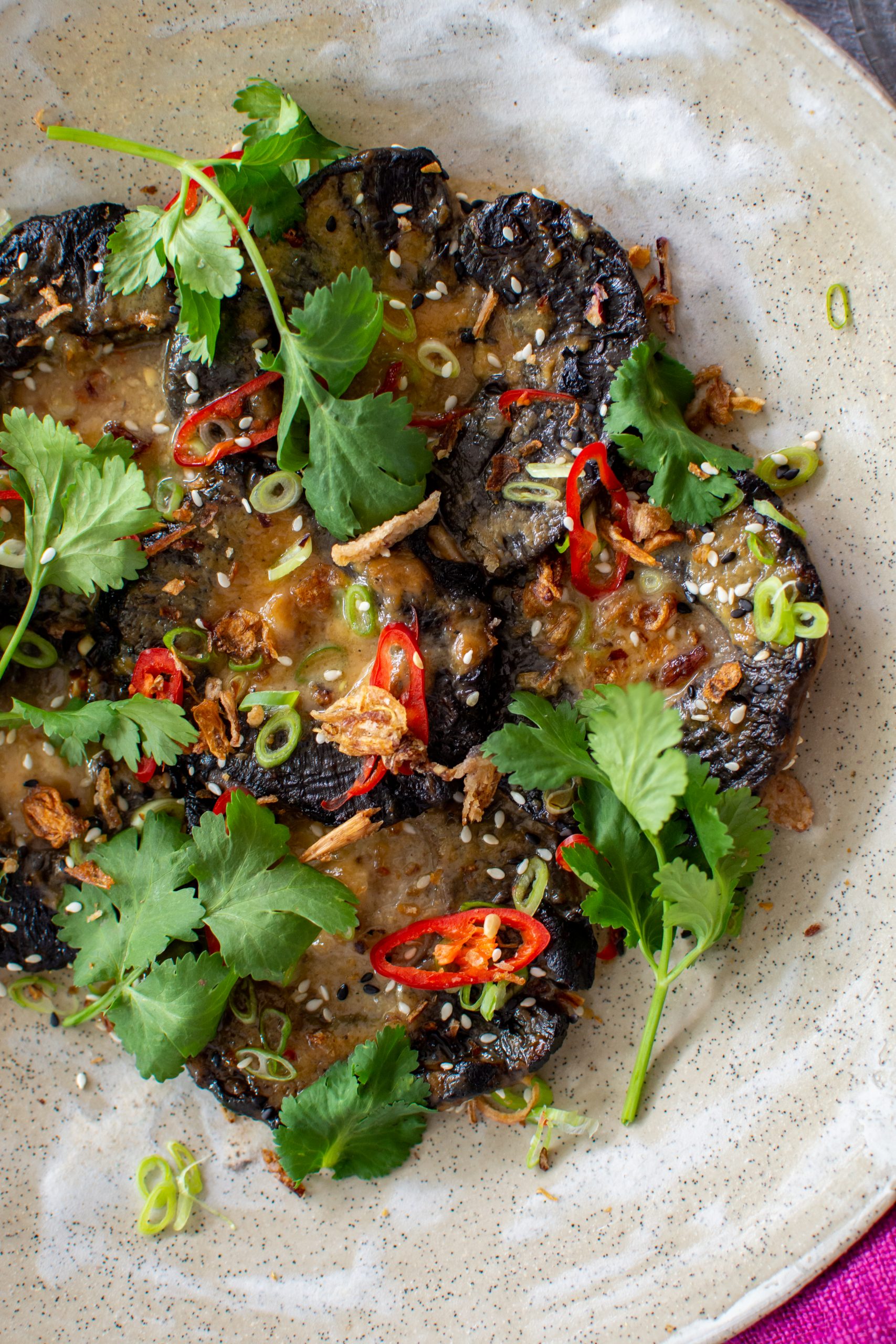 Birdseye view of grilled miso mushrooms topped with coriander & chilli 