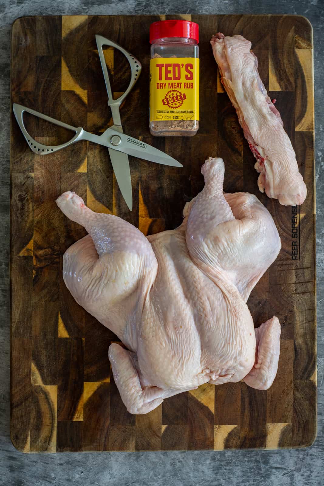 Birdseye view of a spatchcocked chicken on a chopping board 