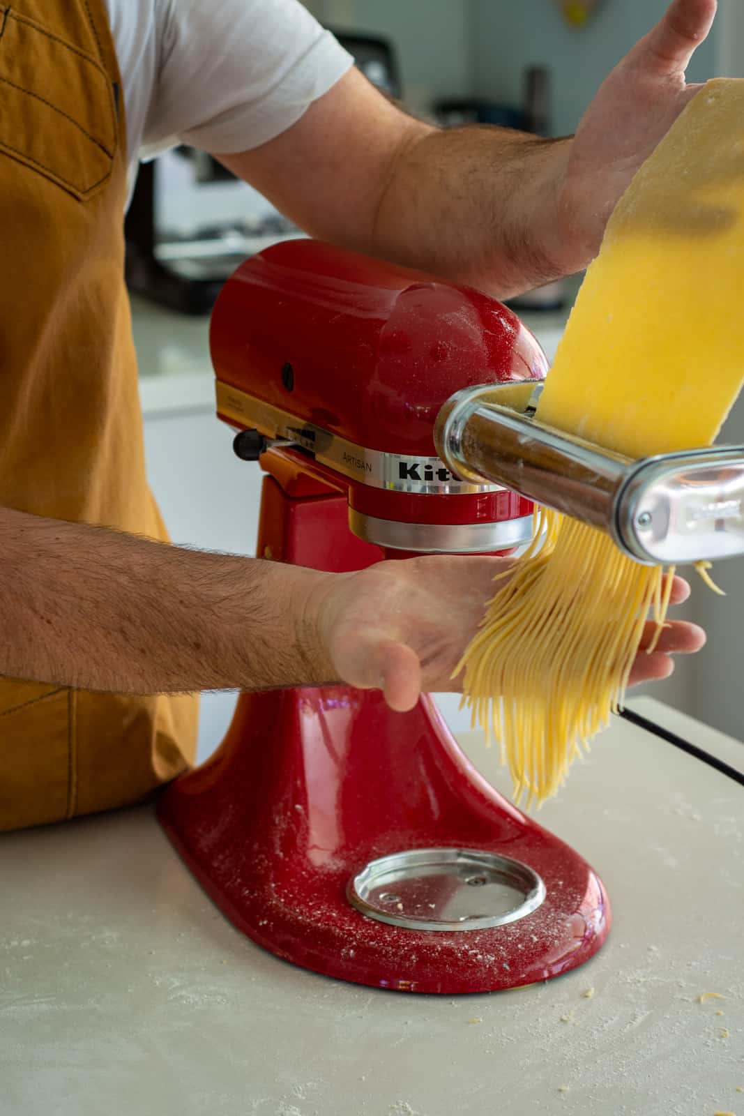 someone making spaghetti using a kitchen aid