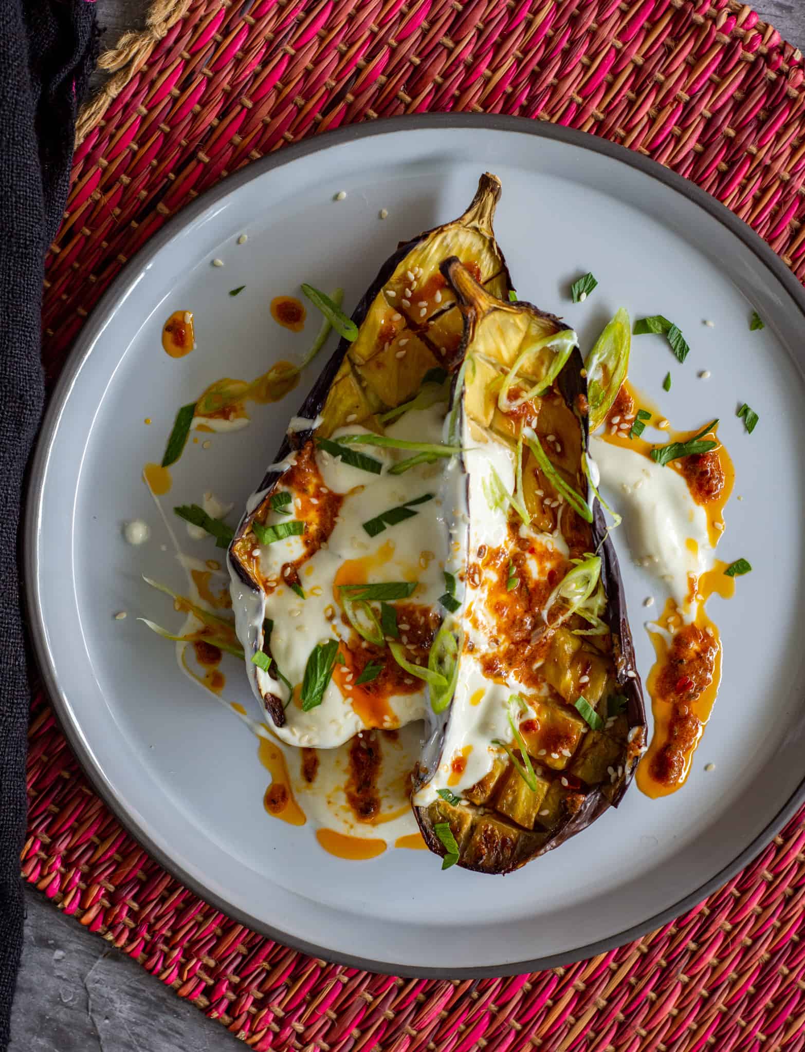 Roasted aubergine w/ harissa butter on a white plate