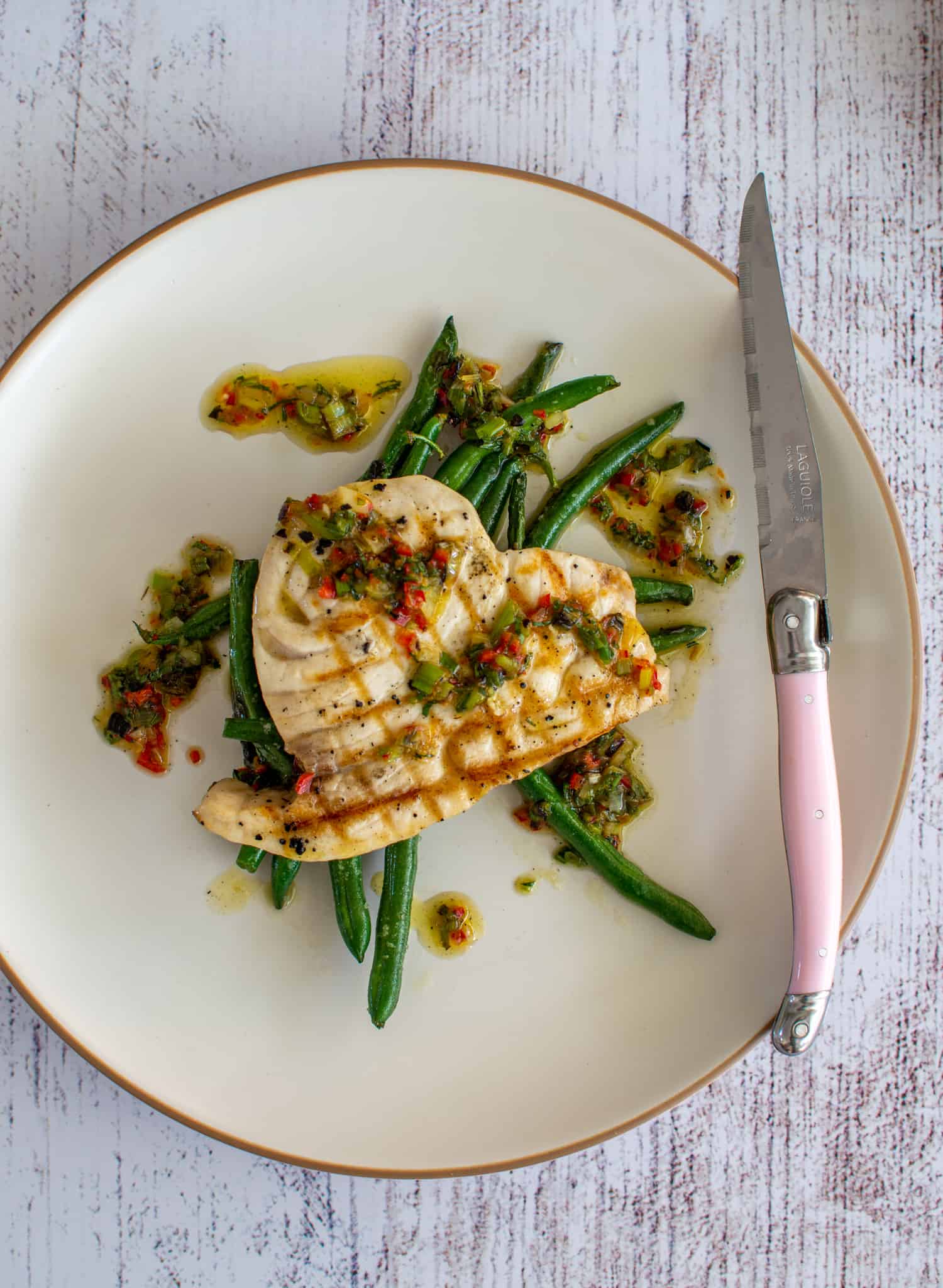 Grilled swordfish steak, green bean and spring onion chilli salsa on a plate 