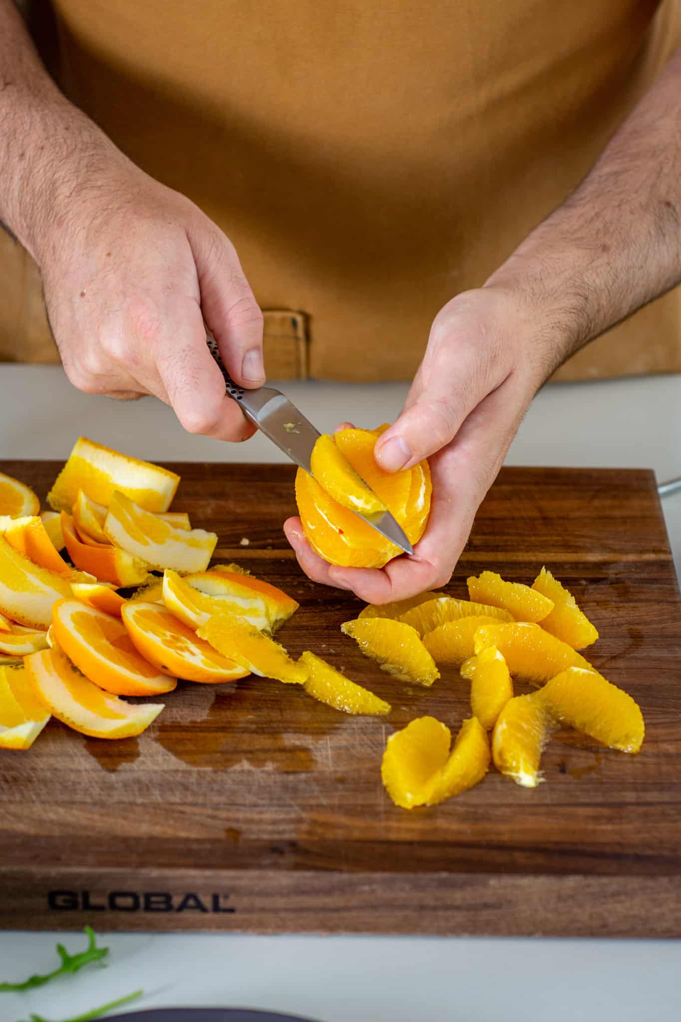 someone segmenting an orange in the kitchen 