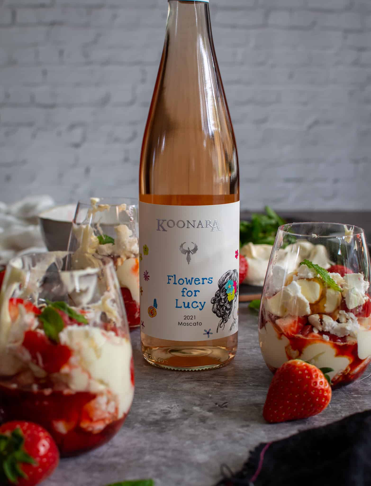 A bottle of Koonara Flowers for Lucy Mostaco with glasses of Eton Mess beside it