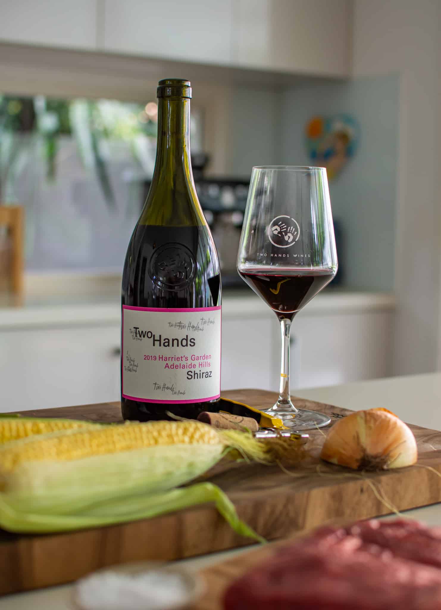A bottle of Two Hands "Harriets Garden" wine in the kitchen with a glass of wine next to it